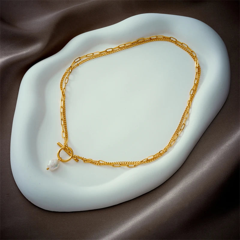 Doppelkette mit Perlenanhänger auf einer hellen Schale – Charmhabit
