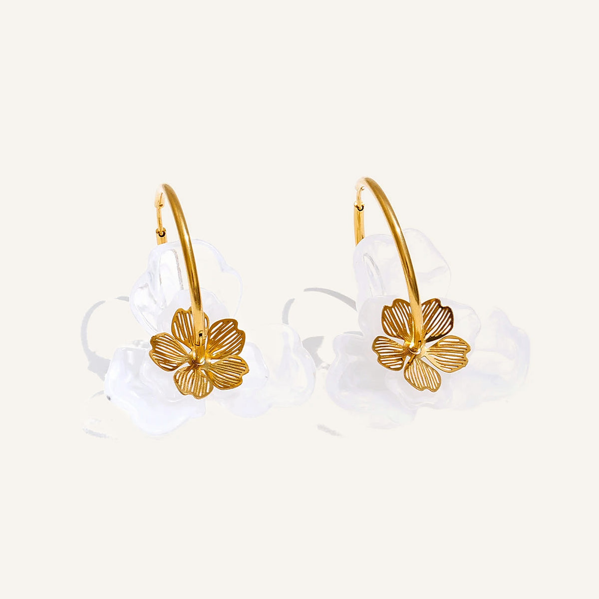 Resin flower hoop earrings with a clear flower on a light background – Charmhabit