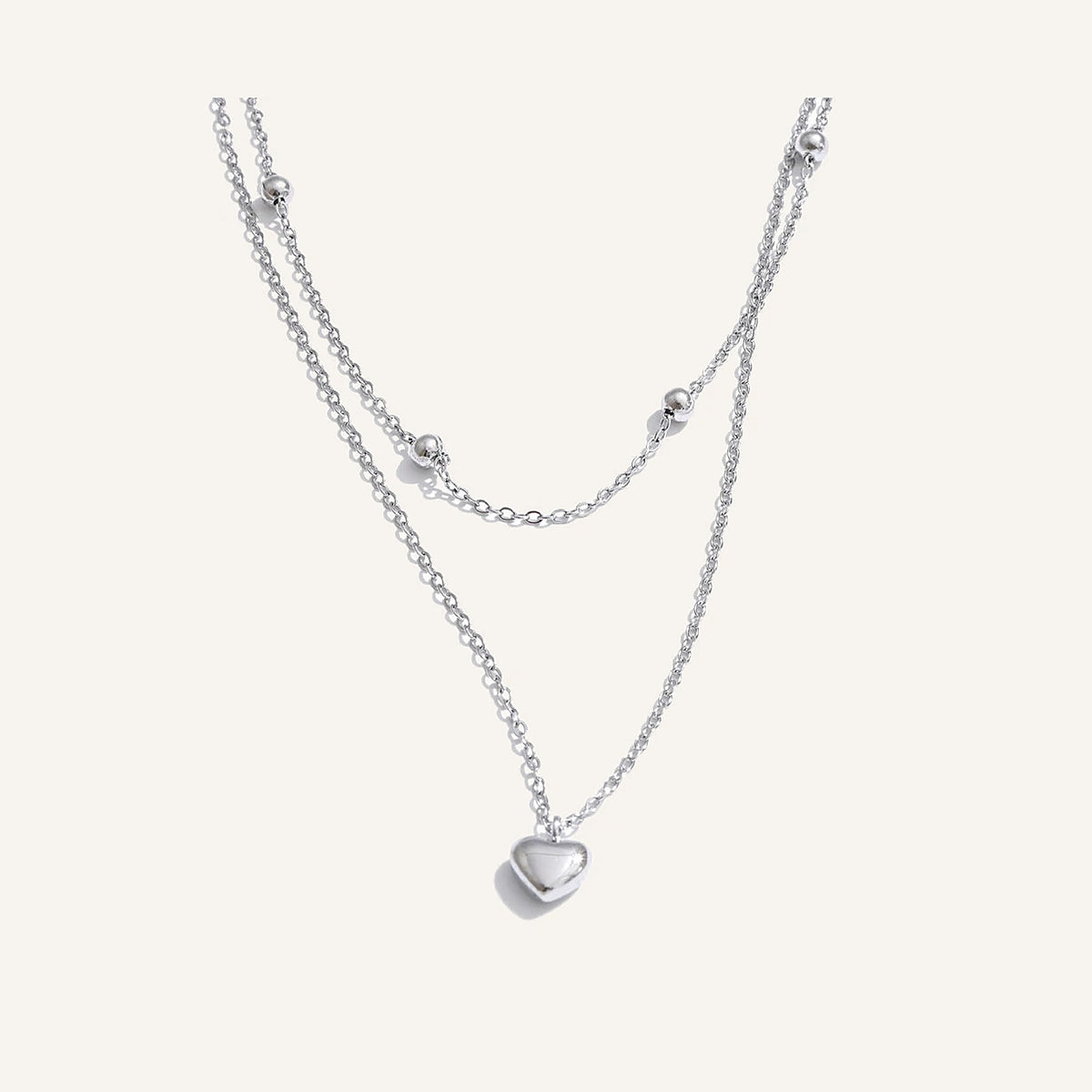 Dubbele ketting met hartjes, zilver, op een lichte achtergrond – Charmhabit