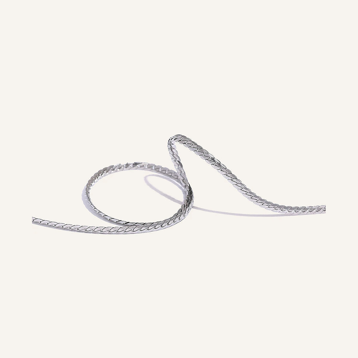 Dünne minimalistische Gliederkette, silberfarben, auf hellem Hintergrund – Charmhabit