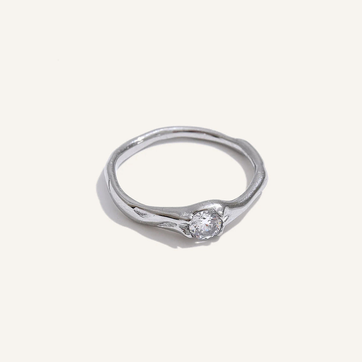 Bague solitaire ondulée avec zircon, argentée, sur fond clair – Charmhabit