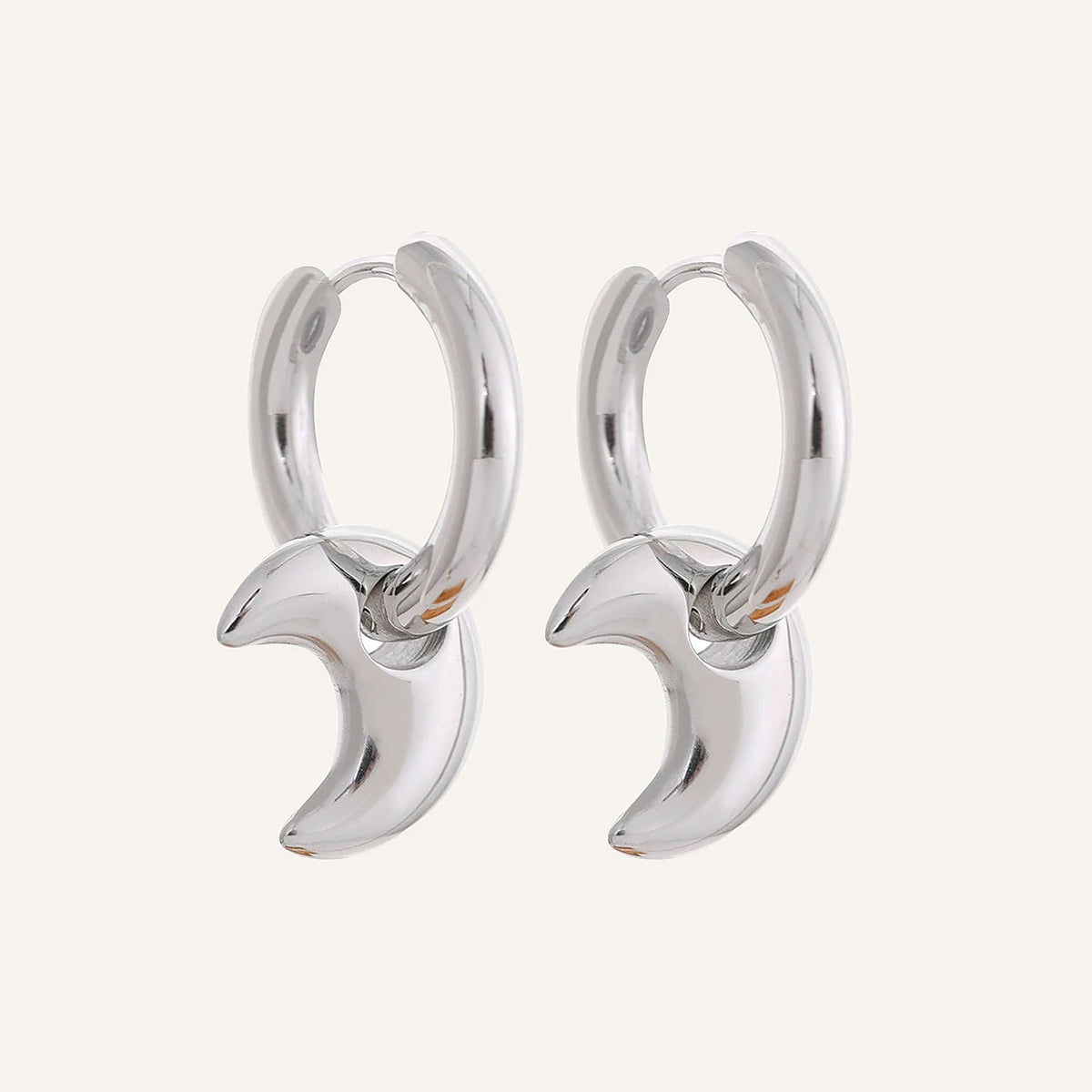 Huggie hoops with moon charm, silver tone, on a light background – Charmhabit