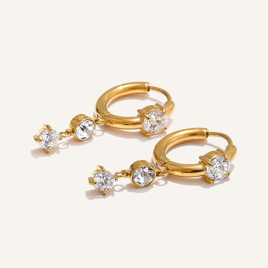 Huggie hoops with a cubic zirconia pendant, gold tone, on a light background – Charmhabit