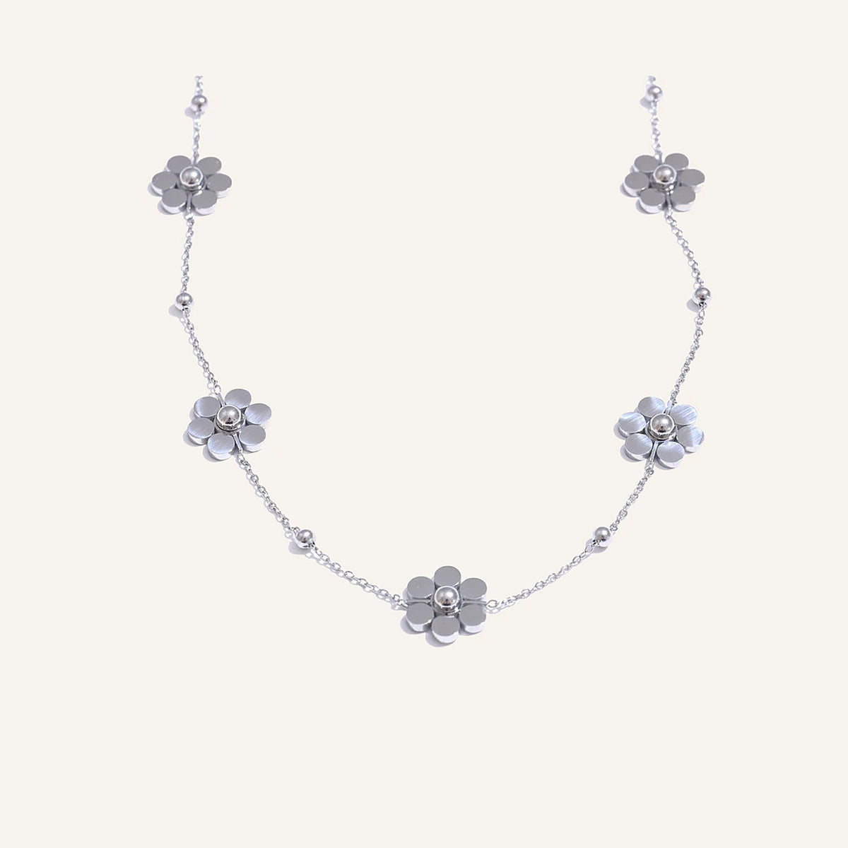 Collier avec petites fleurs, argenté, sur fond clair – Charmhabit