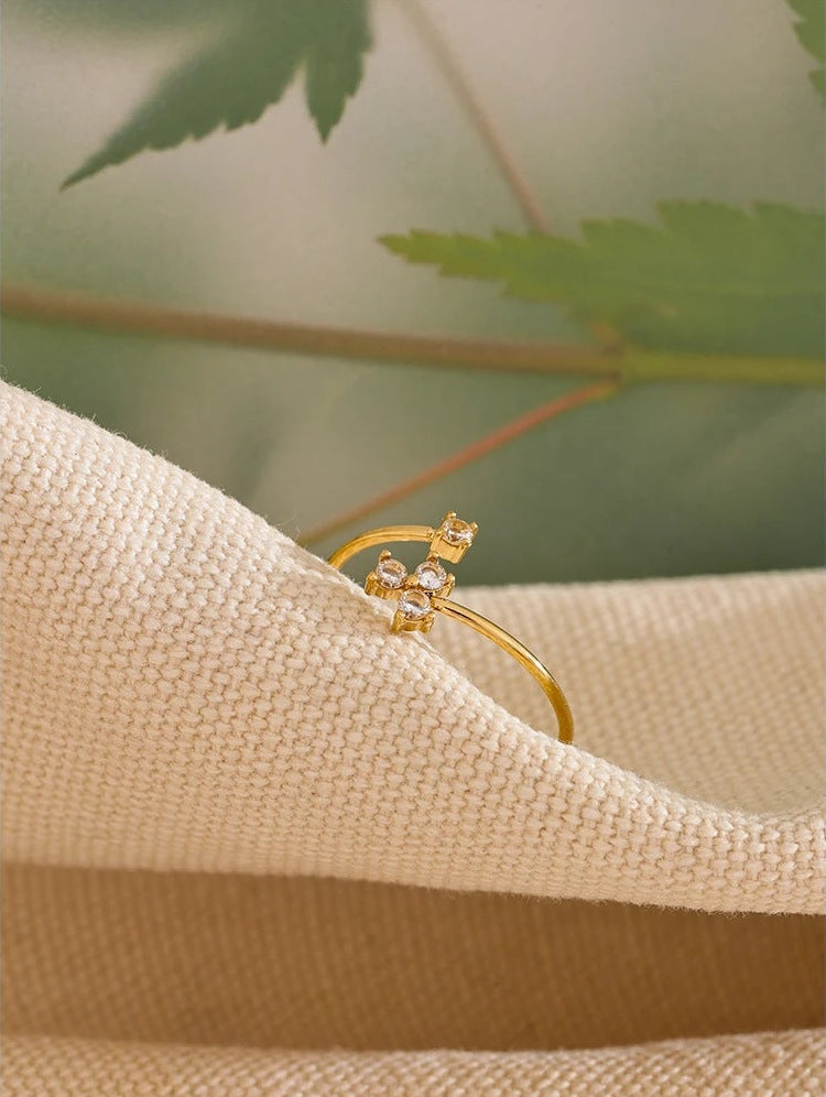 Offener Ring mit vier Zirkonia in Kleeblattform, auf Leinen mit Grün – Charmhabit