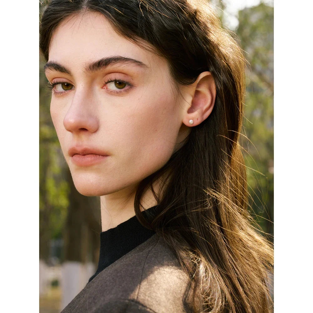 Pearl stud earring worn in the ear