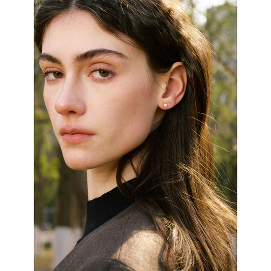 Pearl stud earring worn in the ear