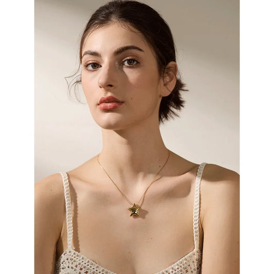 Gold-tone star necklace worn around the neck