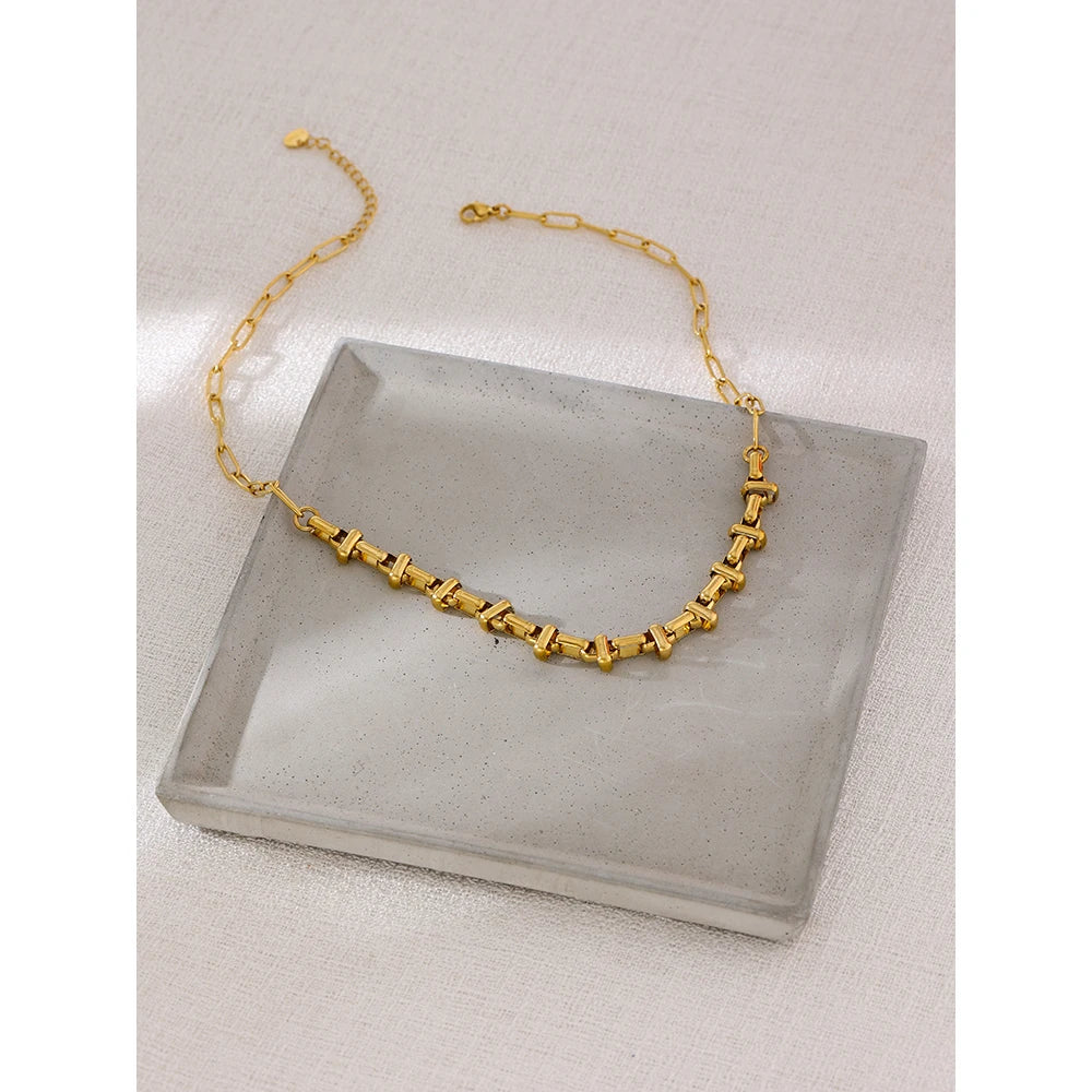 Short choker with gold-tone links in a styled shot – Charmhabit