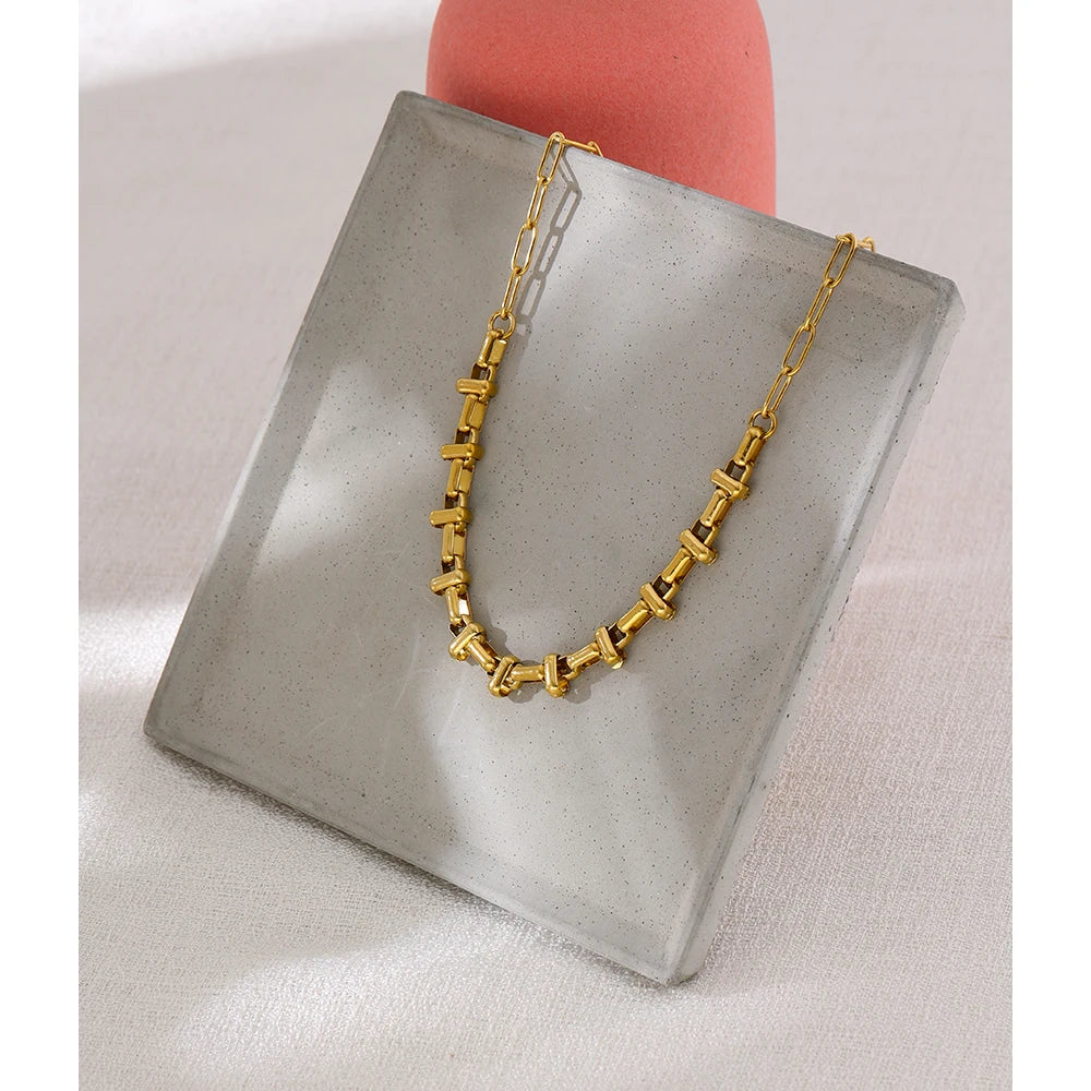 Short choker with gold-tone links in a styled shot – Charmhabit