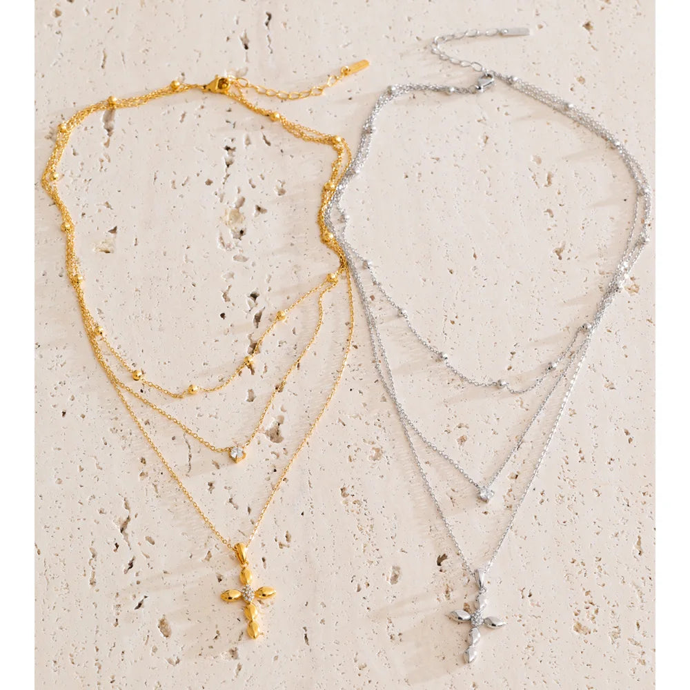 Mehrreihige Kette mit Kreuzanhänger, Gold und Silber, auf Stein – Charmhabit