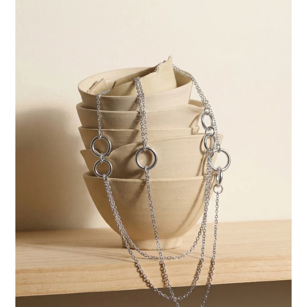 Long collier sur la poitrine, argenté, sur une forme en céramique – Charmhabit