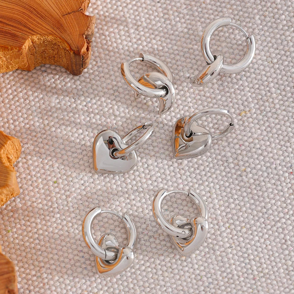 Huggie hoops with charm in silver tone, styled shot on linen – Charmhabit