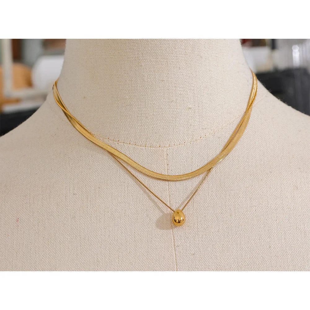 Double-layer necklace with a drop pendant, gold tone, on a linen neck – Charmhabit