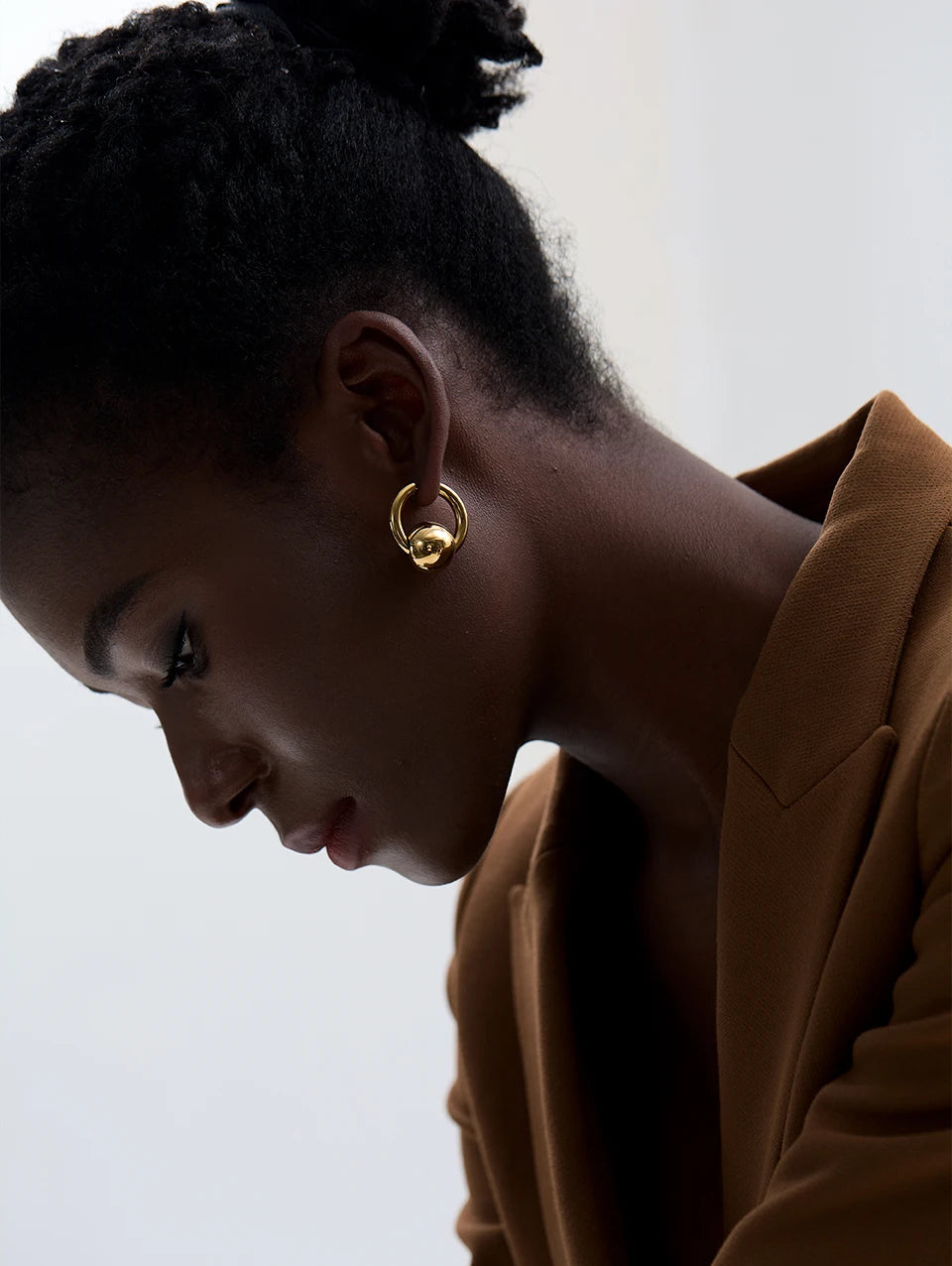 Hoop earrings with a gold or silver tone sphere, gold, worn from the side – Charmhabit