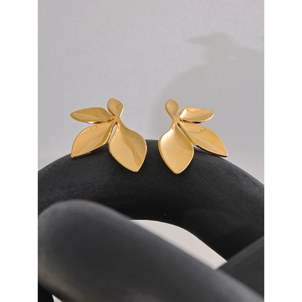 Clous d’oreilles en forme de feuille, dorés, sur tissu sombre – Charmhabit