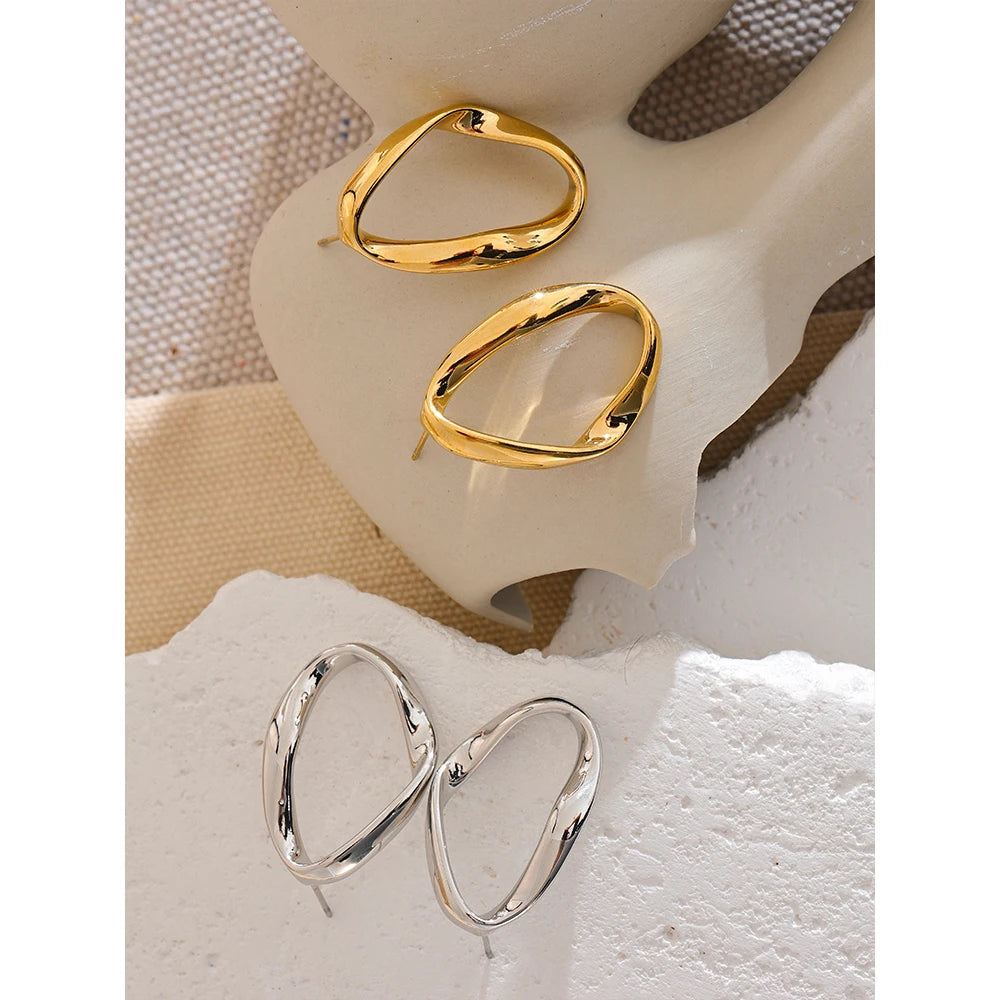 Open oval stud earrings in gold and silver on linen – Charmhabit