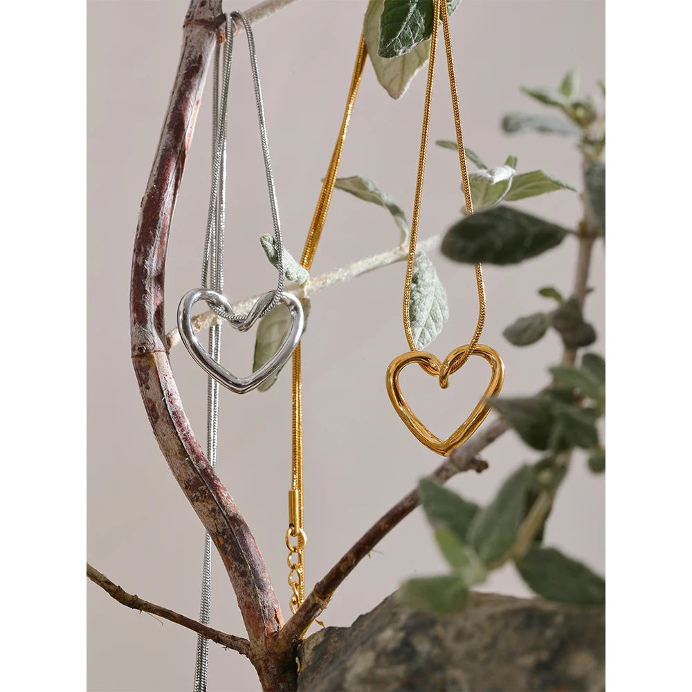 Necklace with open heart, gold and silver tone, hanging from a branch – Charmhabit