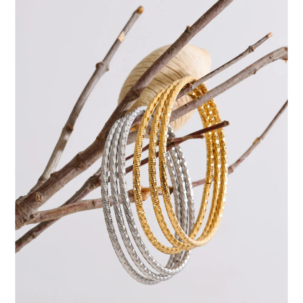 Set aus drei gedrehten Armbändern, Gold und Silber, an einem Zweig – Charmhabit
