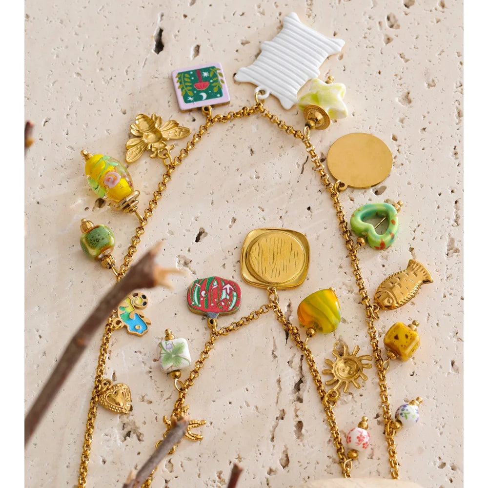 Collier superposé avec breloques colorées, doré, gros plan sur pierre – Charmhabit
