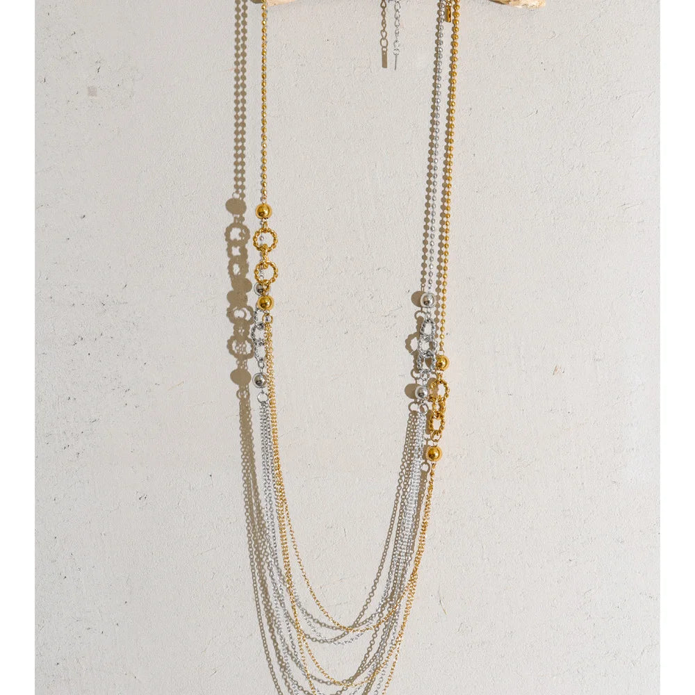 Long layered necklace, gold and silver tone, on a light surface – Charmhabit