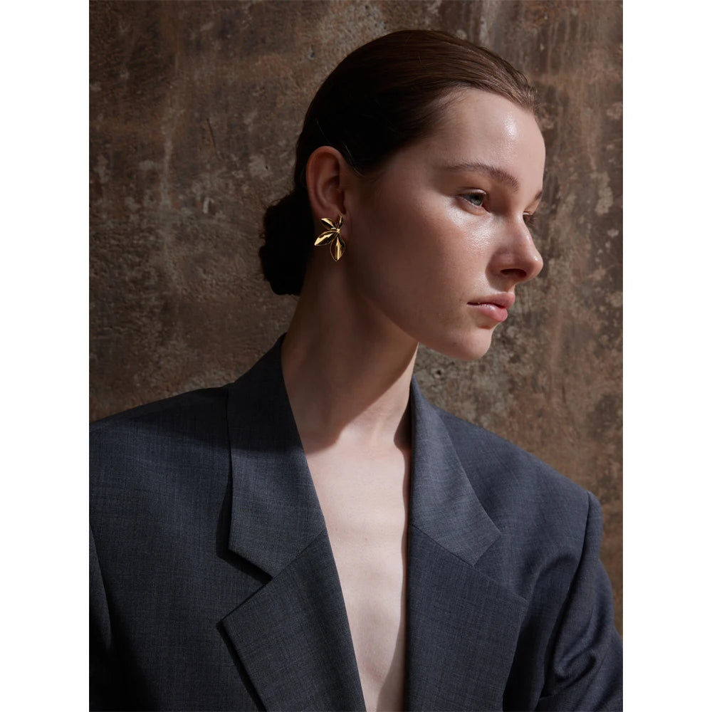 Clous d’oreilles en forme de feuille, dorés, portés de profil – Charmhabit