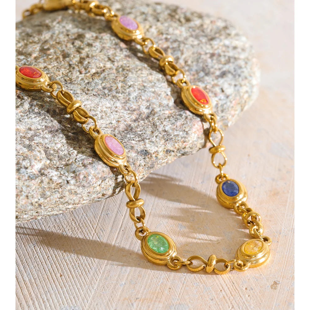 Collier orné de zircons ovales colorés, doré, gros plan sur une pierre – Charmhabit