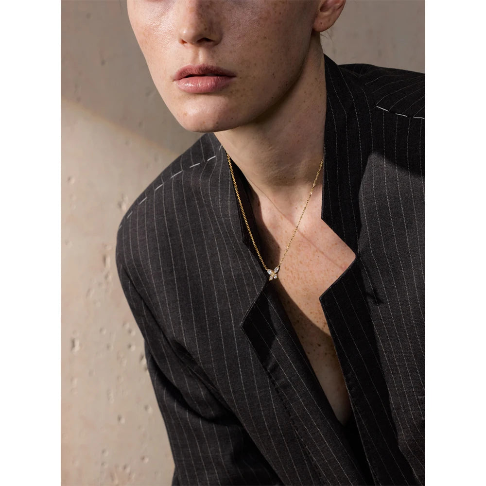 Butterfly necklace with cubic zirconia in a gold tone, worn with a blazer – Charmhabit
