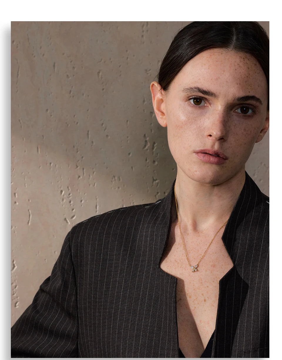 Butterfly necklace with cubic zirconia in a gold tone, worn, close-up – Charmhabit