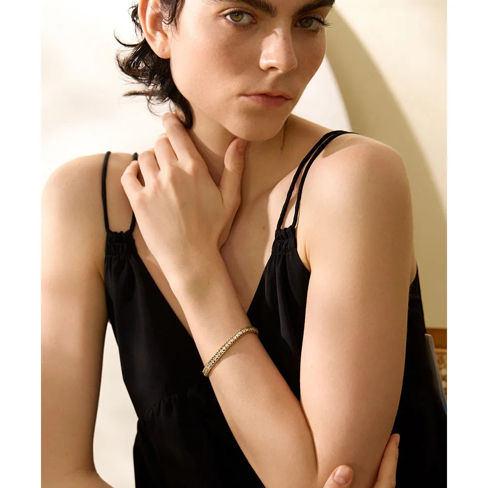 Schakelarmband met zirkonia, gedragen met een hand bij de hals – Charmhabit