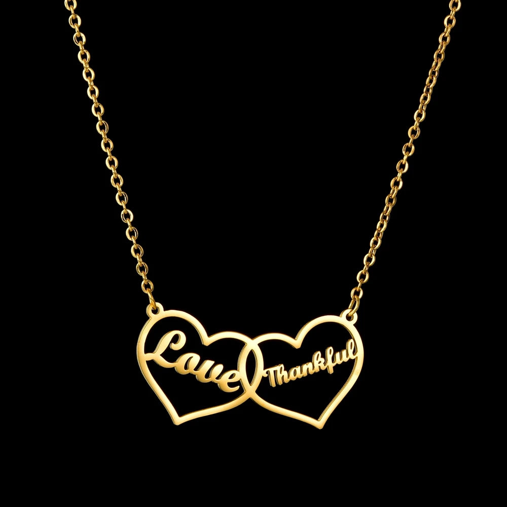 Goudkleurige ketting met twee verbonden hartjes en voorbeeldnamen Love en Thankful