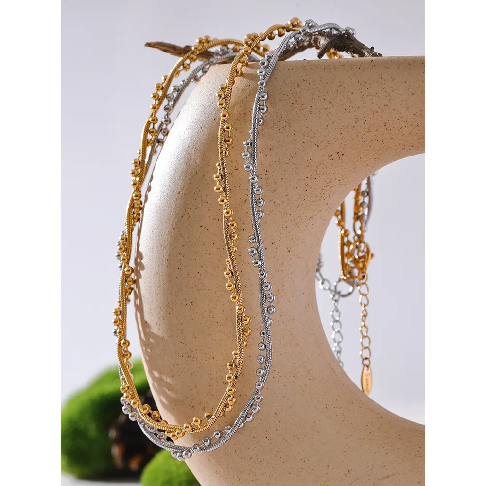 Gedraaide ketting met bolletjes, goud en zilver, op een keramische vorm – Charmhabit