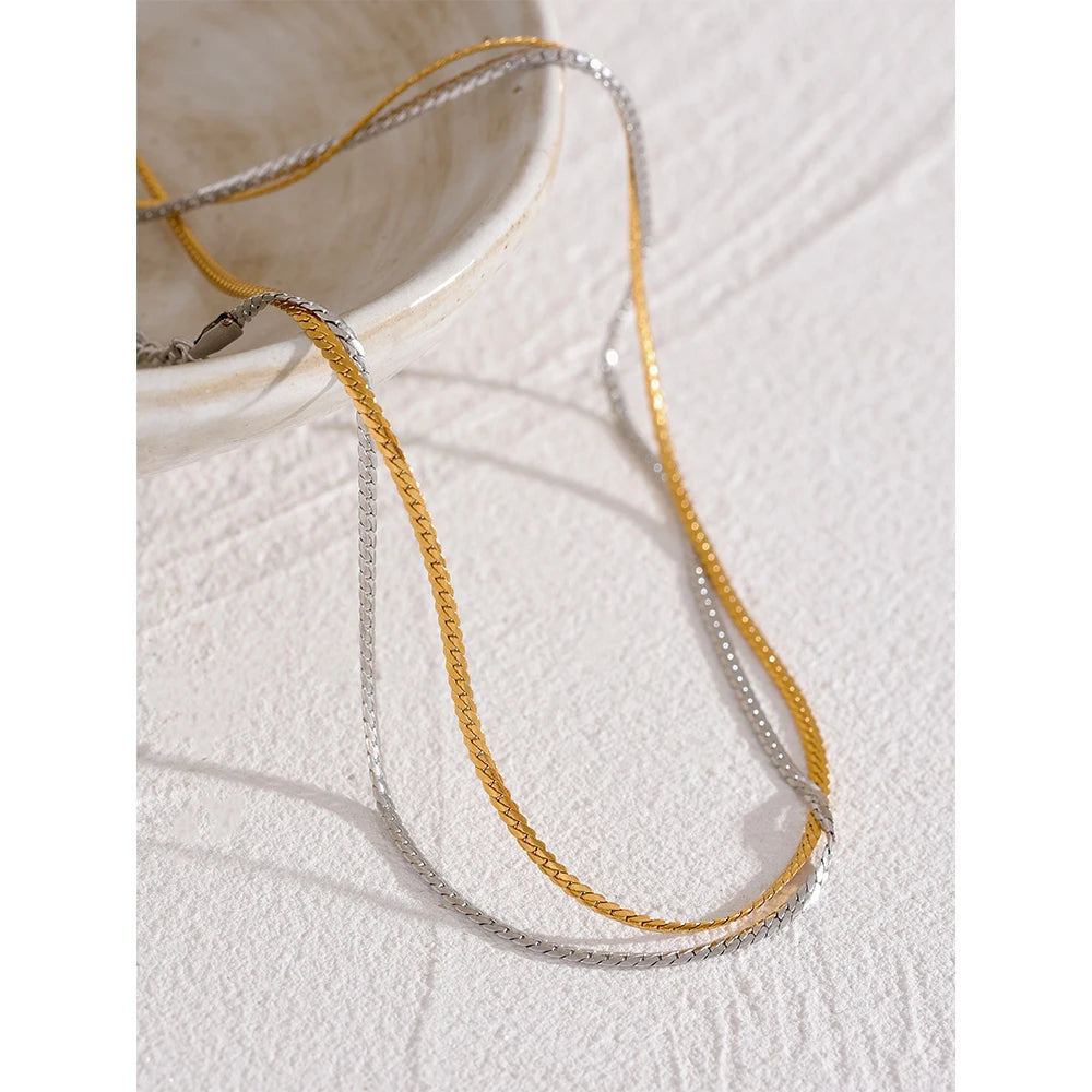 Dünne minimalistische Gliederkette, Gold und Silber, Nahaufnahme in einer kleinen Schale – Charmhabit