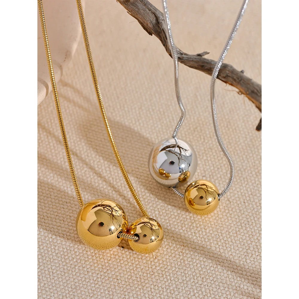 Collier à deux boules, doré et argenté, photo d'ambiance sur du lin – Charmhabit