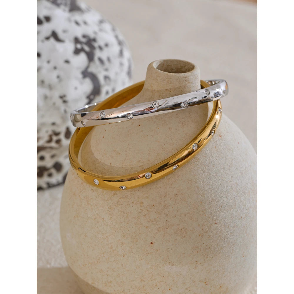 Bangle bracelet with zirconia, gold and silver tone, close-up on a vase – Charmhabit