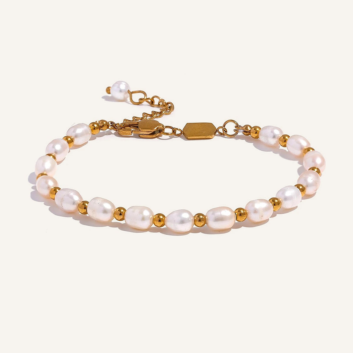 Perlenarmband mit Kugeln, goldfarben, auf hellem Hintergrund – Charmhabit