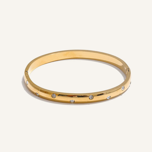 Bangle bracelet with zirconia, gold tone, on a light background – Charmhabit