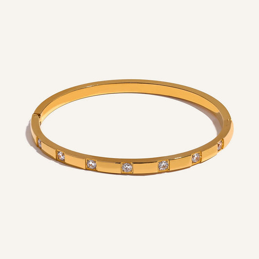 Bangle with a row of cubic zirconia, gold tone, on a light background – Charmhabit