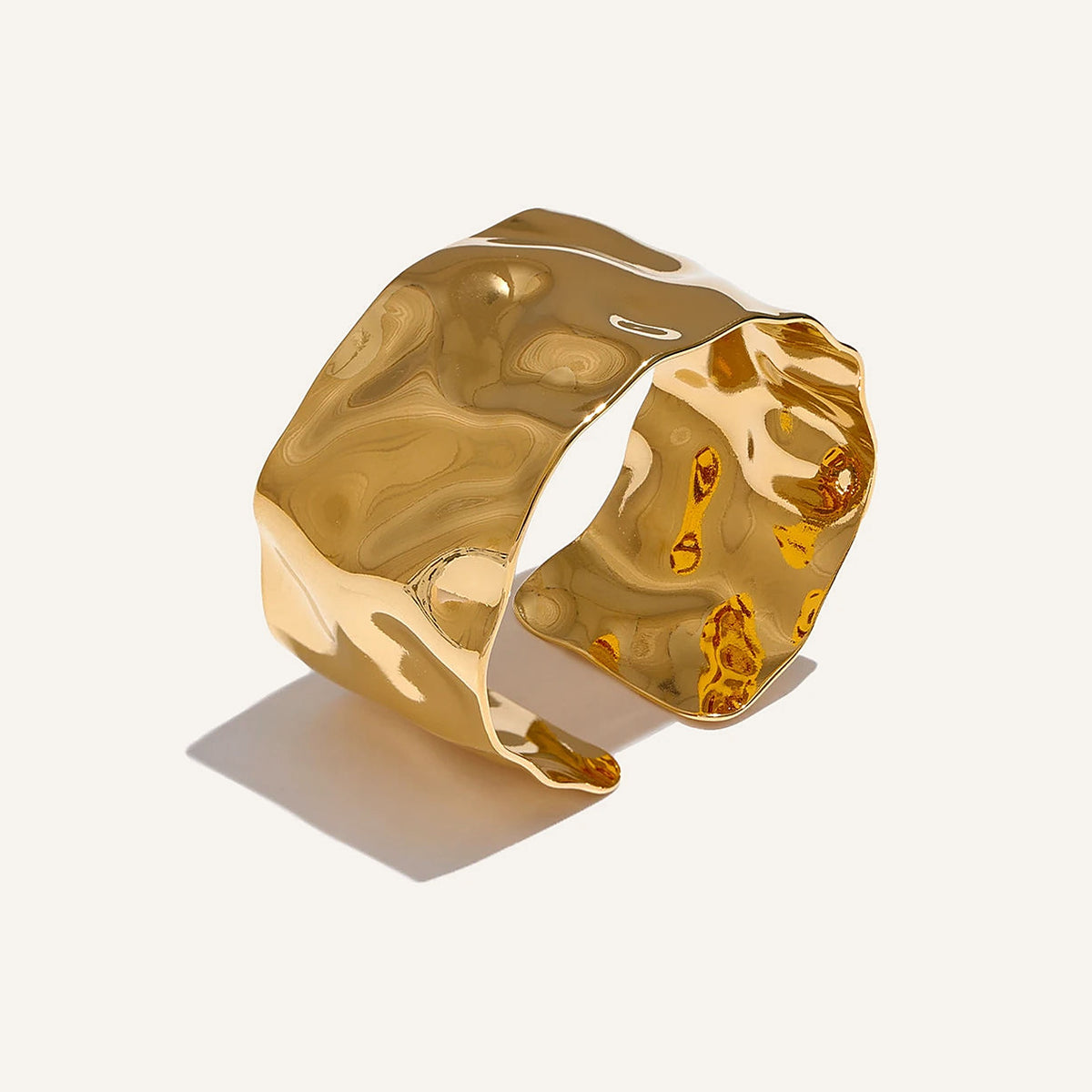 Wide hammered cuff bracelet, gold tone, on a light background – Charmhabit
