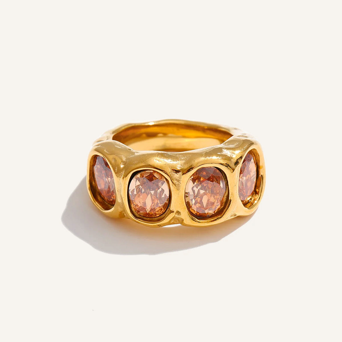 Bague large avec zircons couleur champagne, dorée, sur fond clair – Charmhabit