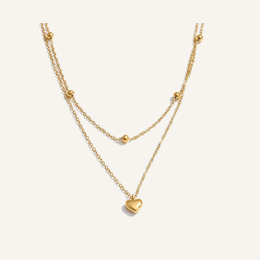 Double necklace with small hearts, gold tone, on a light background – Charmhabit