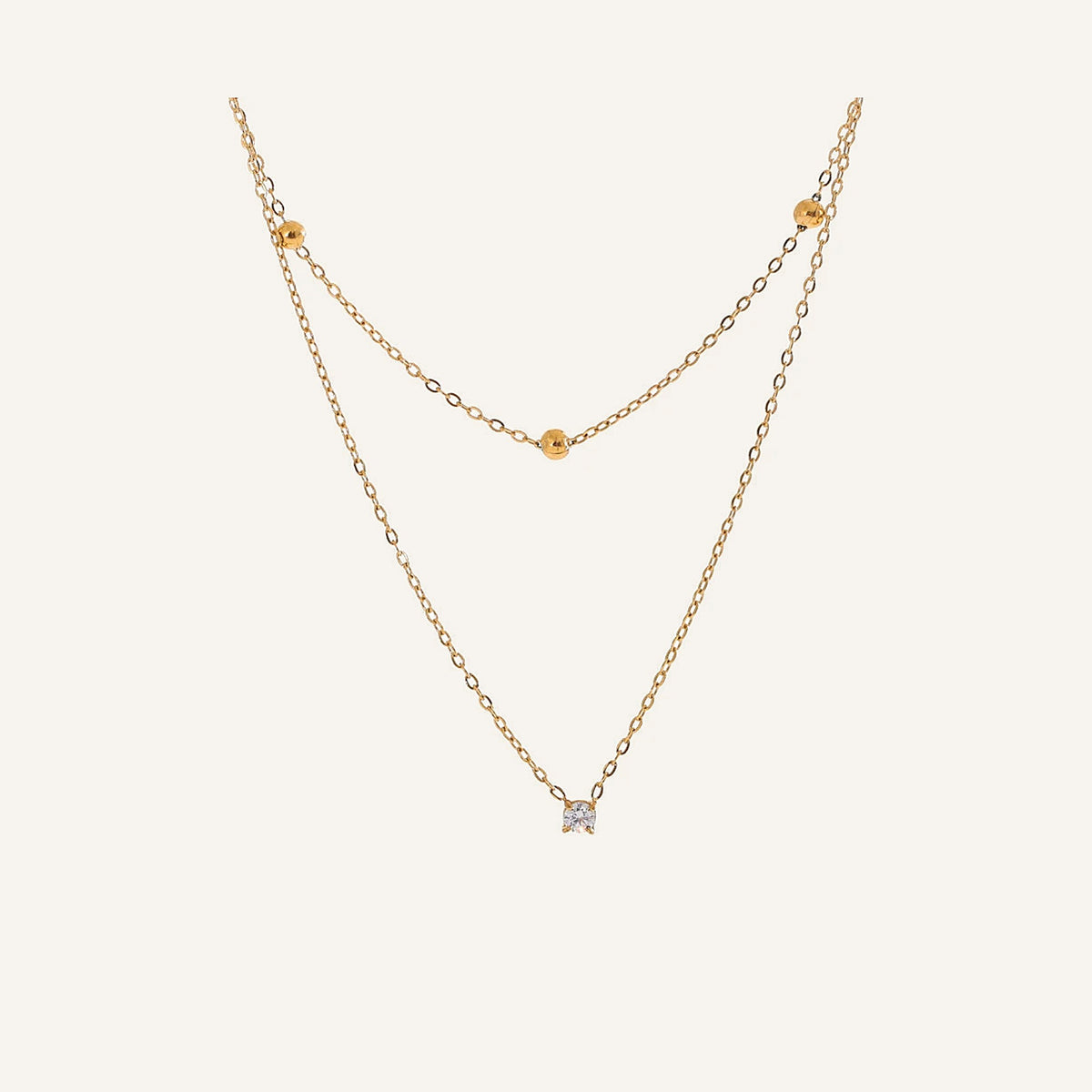 Dubbele ketting met zirkonia, goud, op een lichte achtergrond – Charmhabit