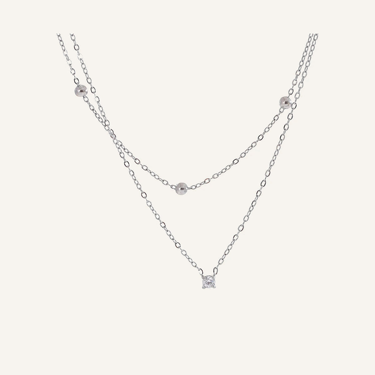 Dubbele ketting met zirkonia, zilver, op een lichte achtergrond – Charmhabit