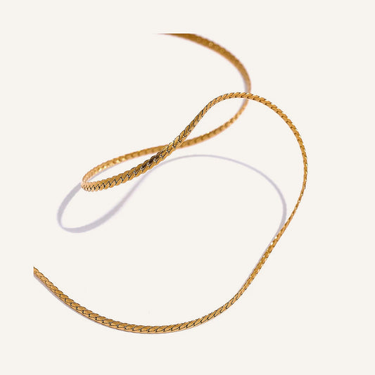 Thin minimalist chain necklace, gold tone, on a light background – Charmhabit