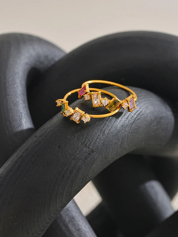 Bague fine avec zircons colorés sur une forme tressée – Charmhabit