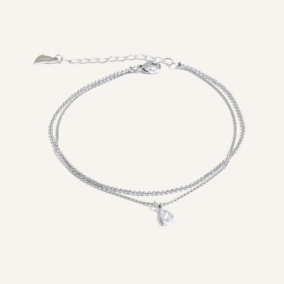 Double anklet with cubic zirconia drop, silver tone, on a light background – Charmhabit