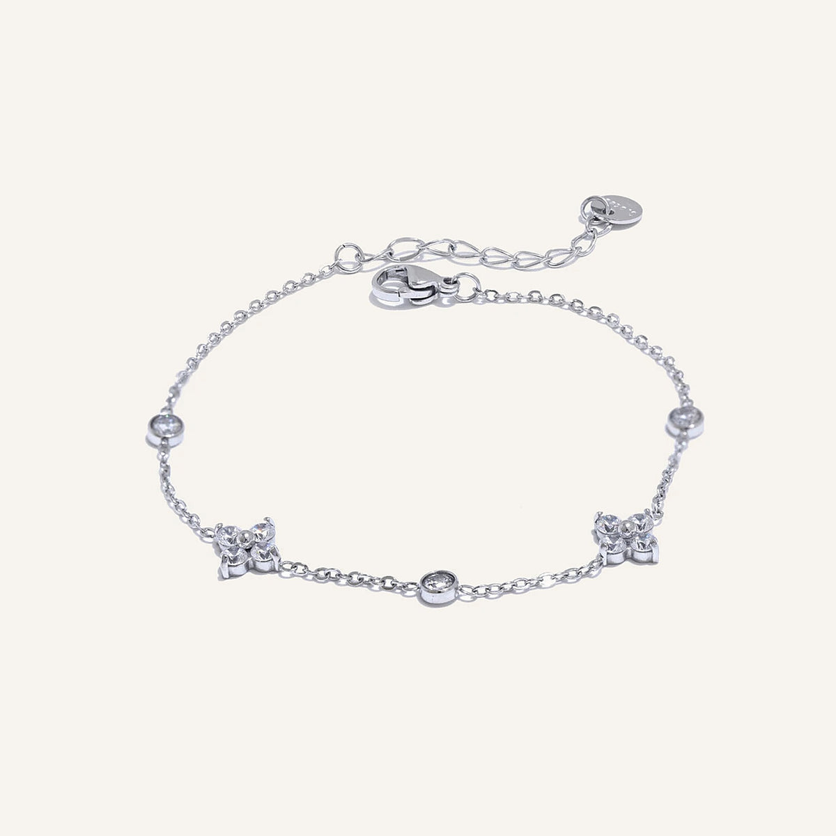 Feines Armband mit Zirkonia-Blüten, silberfarben, auf hellem Hintergrund – Charmhabit