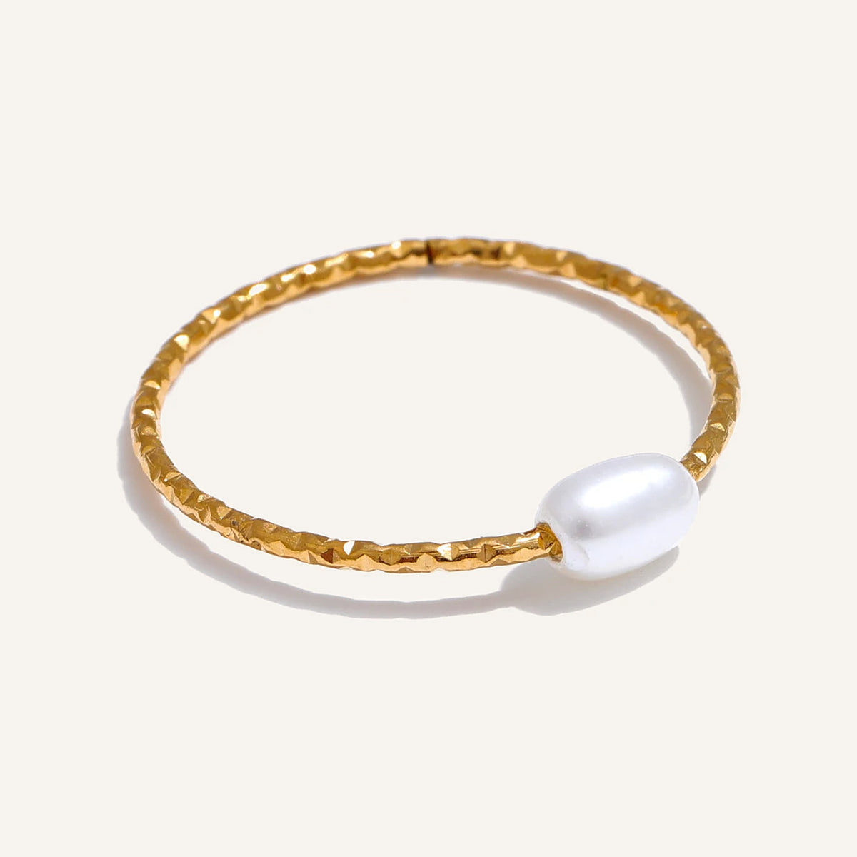 Feiner Perlenring, goldfarben, auf hellem Hintergrund – Charmhabit