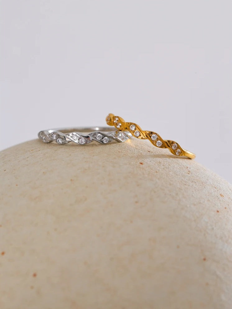 Gedrehte Ringe mit Zirkonia, gold- und silberfarben, auf einem runden Stein – Charmhabit