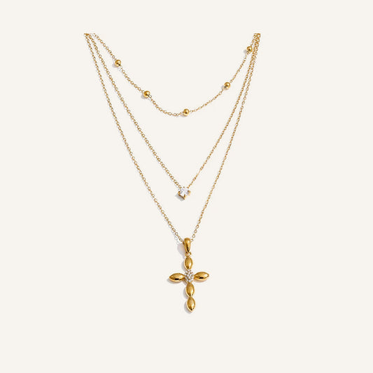 Layered necklace with cross pendant, gold tone, on a light background – Charmhabit